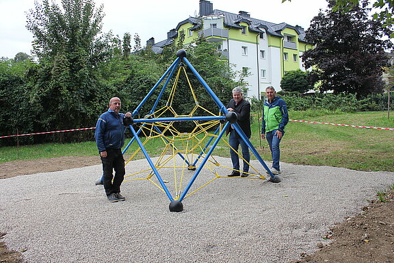 Ein Klettergerüst inmitten der "Grünen Insel" Adalbert-Stifter-Straße. Bürgermeister Josef Leitner, Bauamtsleiter Thomas Lichtenschopf und Wassermeister Robert Picker stehen daneben.