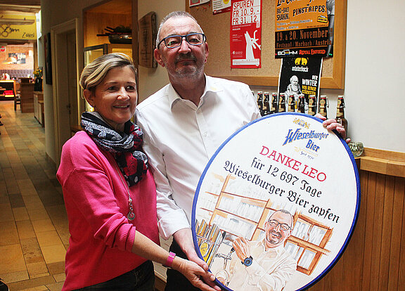 Margit Hauer von der Brauerei Wieselburg übergibt Leo Aigner ein handbemaltes Schild.