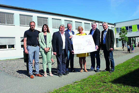Im Innenhof der Volksschule stehen an der Stelle, wo in absehbarer Zeit dazu gebaut wird folgende Personen: Bgm. Josef Leitner, Bgm. Karl Gerstl (Gemeinde Wieselburg-Land, Bildungsstadtrat Gerhard Liebmann, GR Helmut Brandl (Obmann des Mittelschulausschusses), die beiden Direktorinnen Helga Jungwirth (Volksschule) bzw. Waltraud Puppenberger (Mittelschule) und der Architekt Gottfried Haselmeyer. Im Hintergrund sind einige spielende Kinder zu sehen