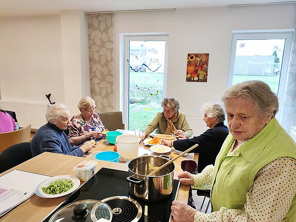 Gäste des Tagesbetreuungszentrums beim gemeinsamen Zubereiten des Mittagessens.