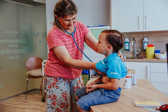 Dr. Tatjana Offenberger hört einen Jungen mit dem Stetoskop ab 