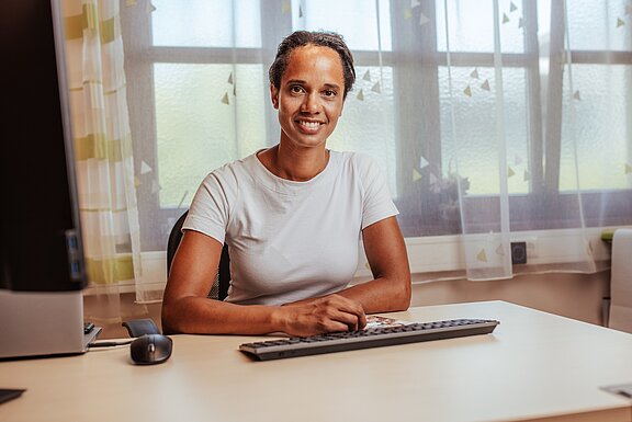 Porträt von Dr. Kehinde Wewe an ihrem Schreibtisch 